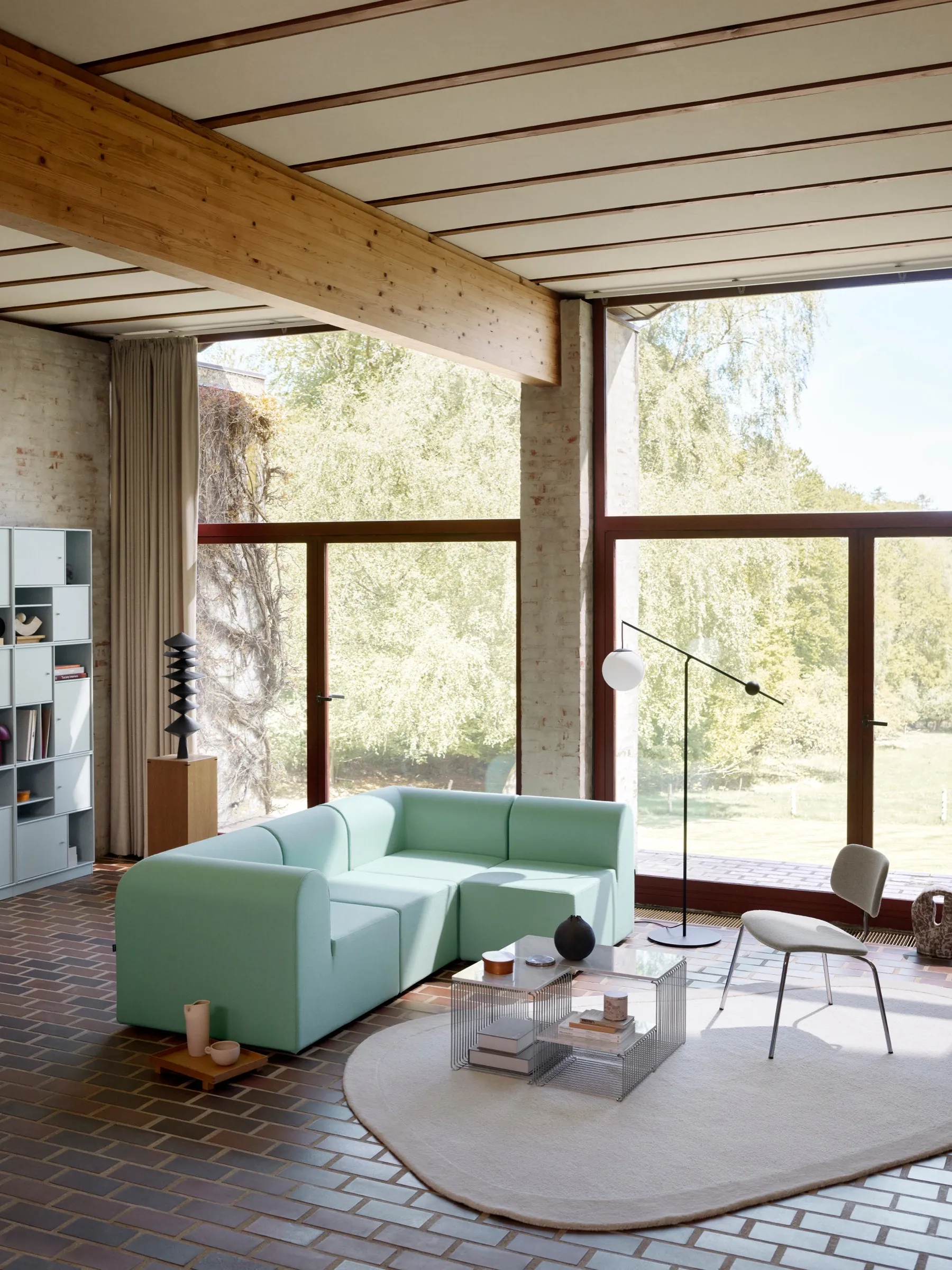 Curated lounge featuring the Paradigm sofa, layered tables, and soft lighting.